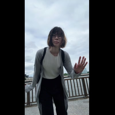 眼鏡をかけた女性が屋外で手をかざす