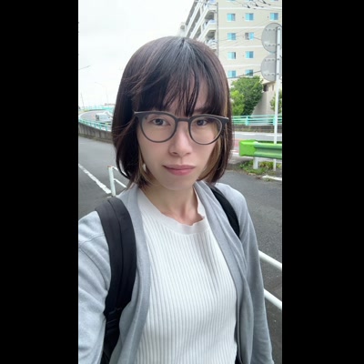 都市風景での自然な笑顔｜眼鏡をかけた20代女性の日常