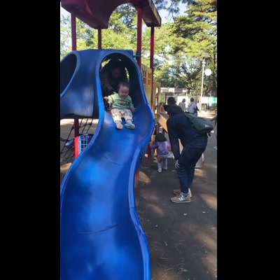 子どもが公園の滑り台を上からワクワク顔でのぞき込む